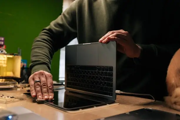 A person carefully cleaning a computer keyboard and monitor.